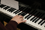 A close up of a mans hand playing the piano