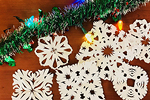 Christmas garland with multicoloured lights with paper cut snowflakes next to it