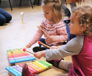 Two children playing colourful musical instruments at a Palace Players session.