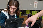 A close up of a participant in front of an iPad creating music