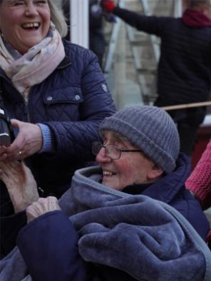 A man and a woman smile and converse while taking part in a photography workshop.