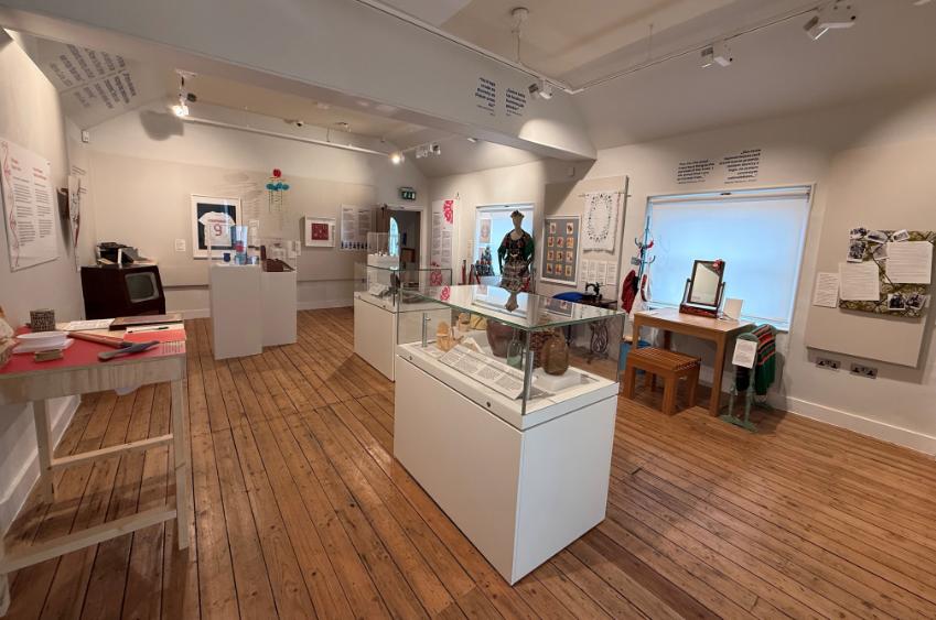 A photo of the From Poland exhibition room, showing all the cases and artifacts on the walls