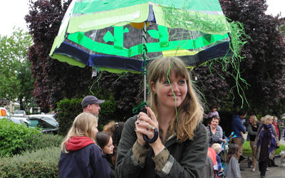 Artist Charlotte Tupper holds an umbrella outdoors