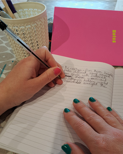 A hand writing with a biro pen in a notebook