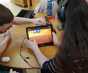 A participant of a music workshop creating music on an iPad
