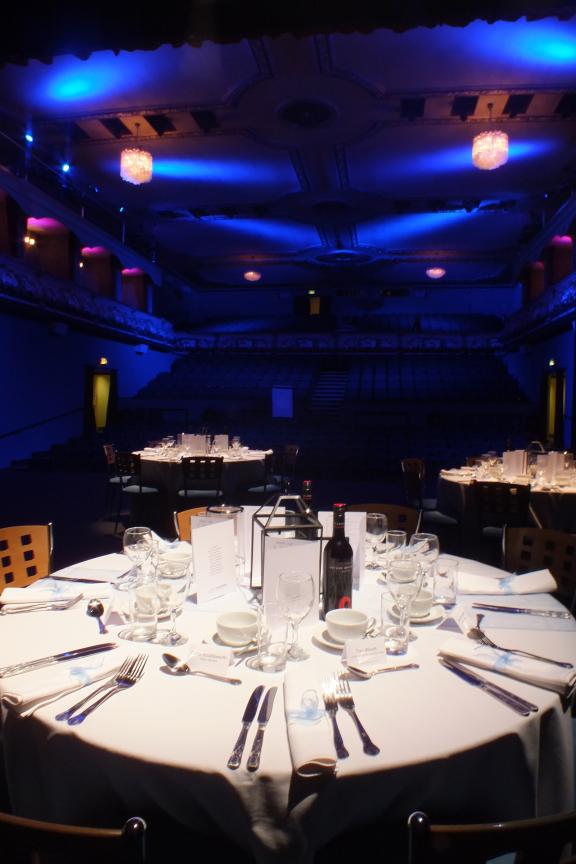 Banquet tables laid on the Palace Theatre stage with auditorium seating in the background.