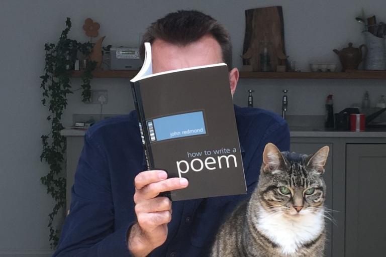 Promotional image for Brian Bilston featuring a person holding a poetry book beside a tabby cat in a home setting.