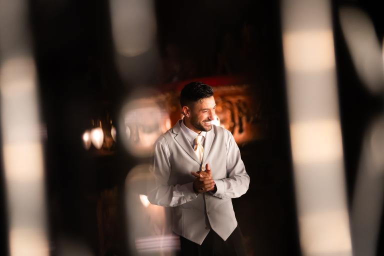 Promotional image for Giovanni: Unstoppable, featuring a performer in a light-coloured waistcoat standing in a warmly lit theatrical setting.