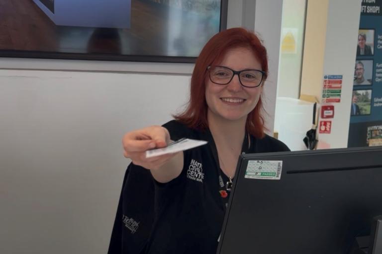 Woman with red hair handing over tickets