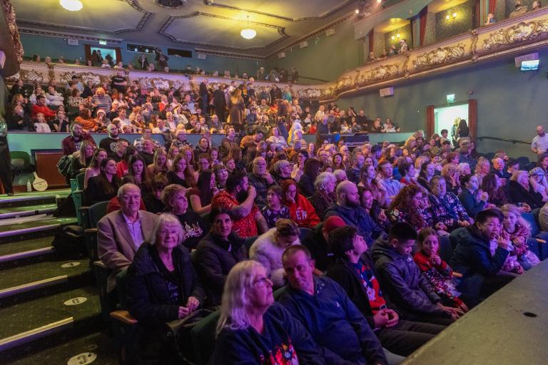 Audience seated inside the Palace Theatre auditorium before a live performance begins.