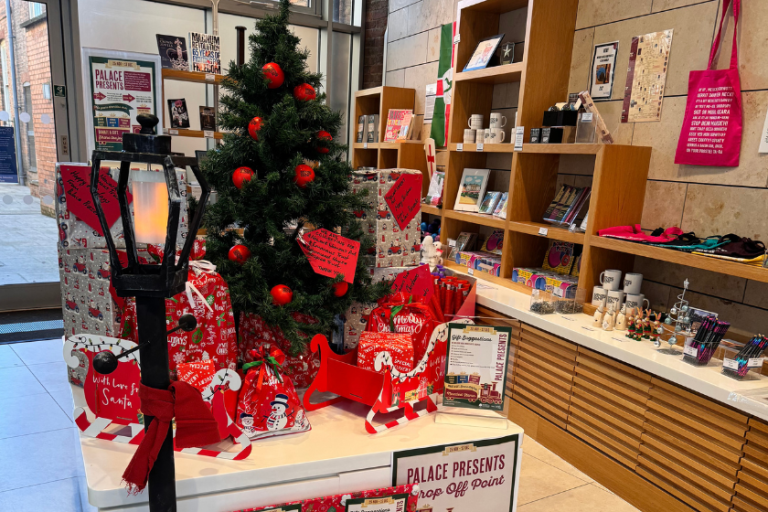 Christmas display in the Palace Theatre foyer with decorated tree, gifts and festive merchandise.