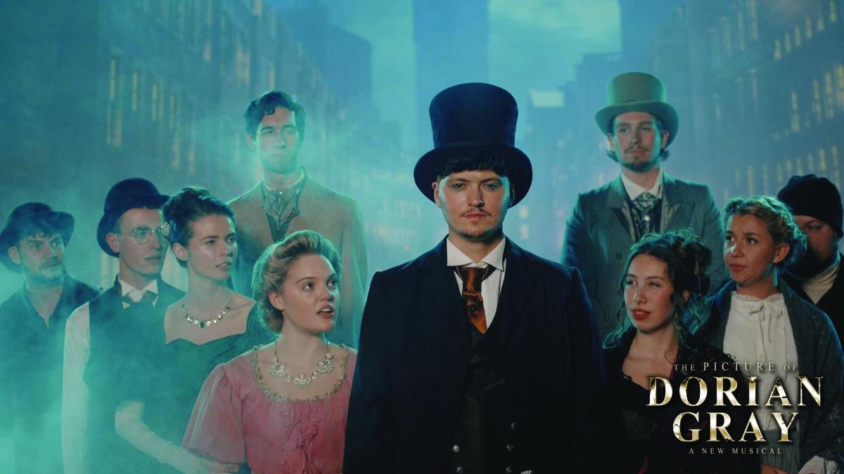 Promotional image for The Picture of Dorian Gray: A New Musical, featuring a cast in Victorian costume standing in a misty, blue-lit city setting.