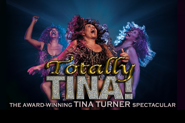 Promotional image for Totally Tina! The Tina Turner Spectacular, featuring performers in sparkling costumes beneath dramatic blue stage lighting.